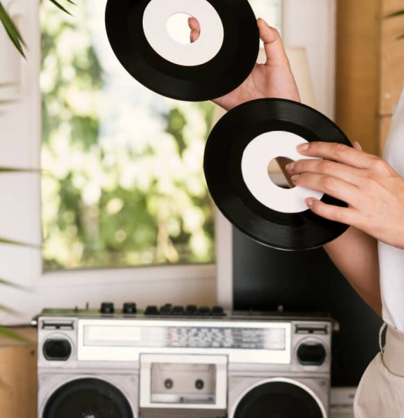 young-person-holding-vintage-vinyl-records-indoors (1)